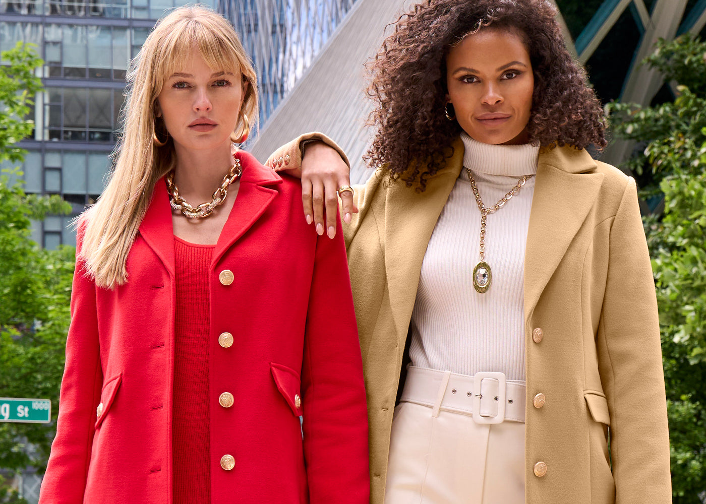 Model 1's wearing a red tailored coat with red sweater dress and model 2's wearing a white turtleneck, white ponte pants and a tan tailored coat.