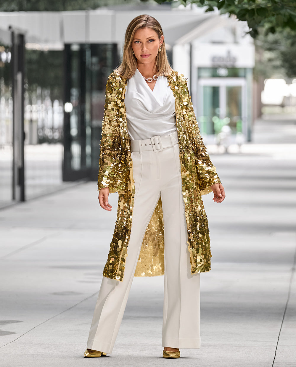 Models wearing a white Marilyn blouse, white ponte pants and a gold sequin duster.